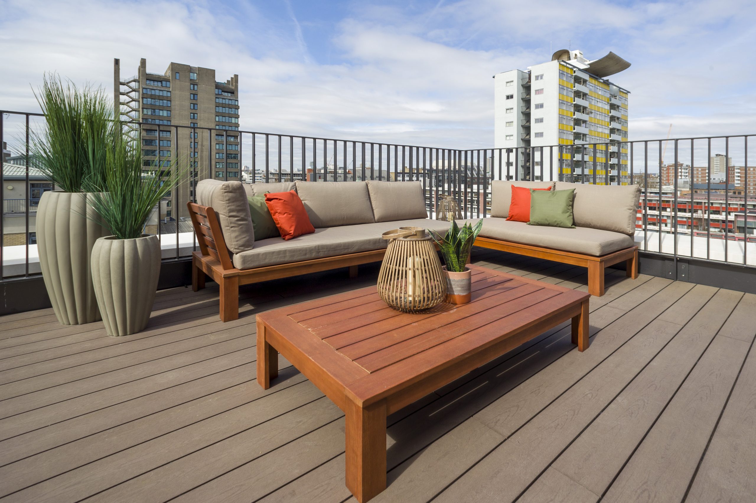 The Denizen Terrace - Grey seating with dark wood low table with plants beside