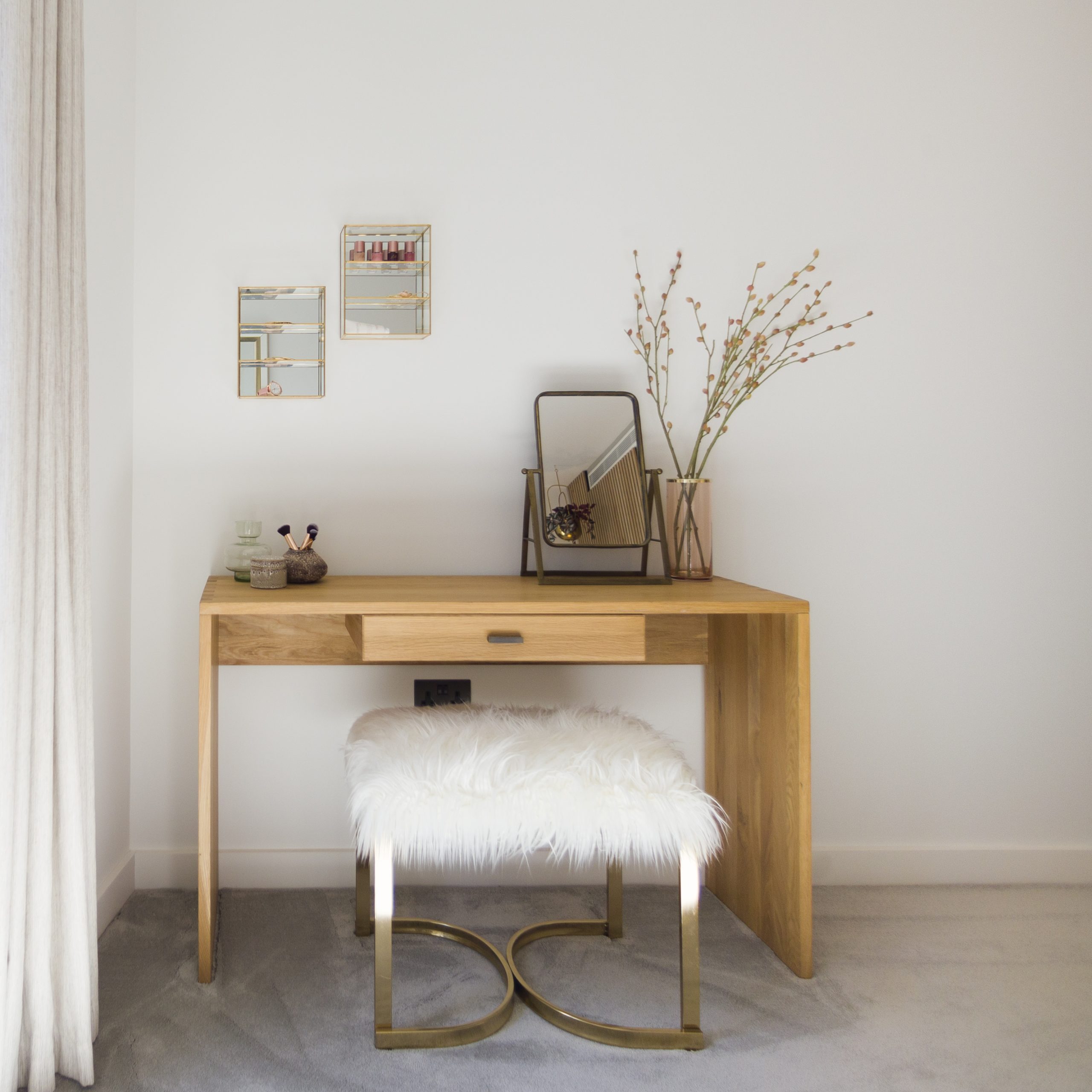 White fluffy stool styled infront of wooden dresser in bedroom