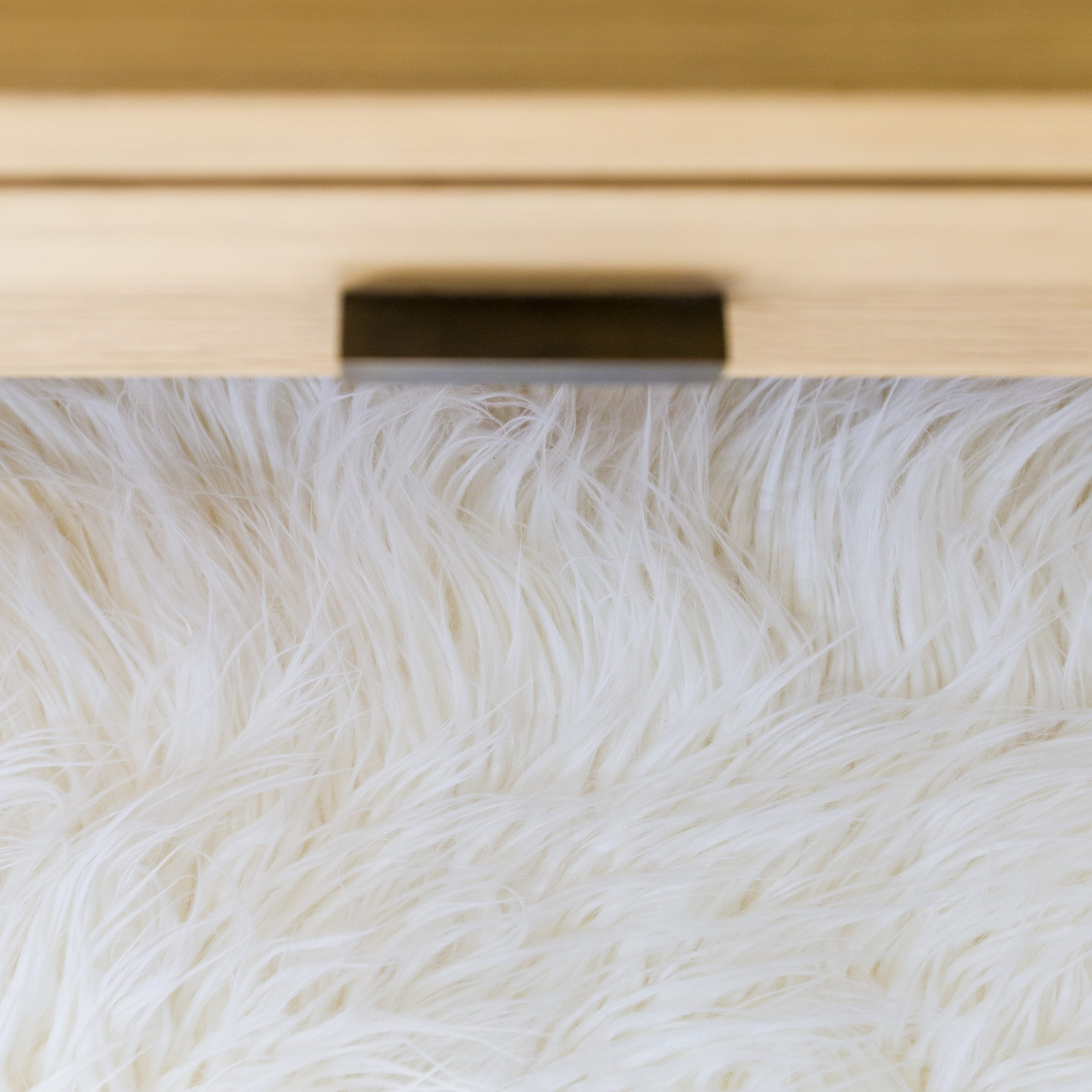 Close-up birds eye view of fluffy stool in bedroom by the dresser