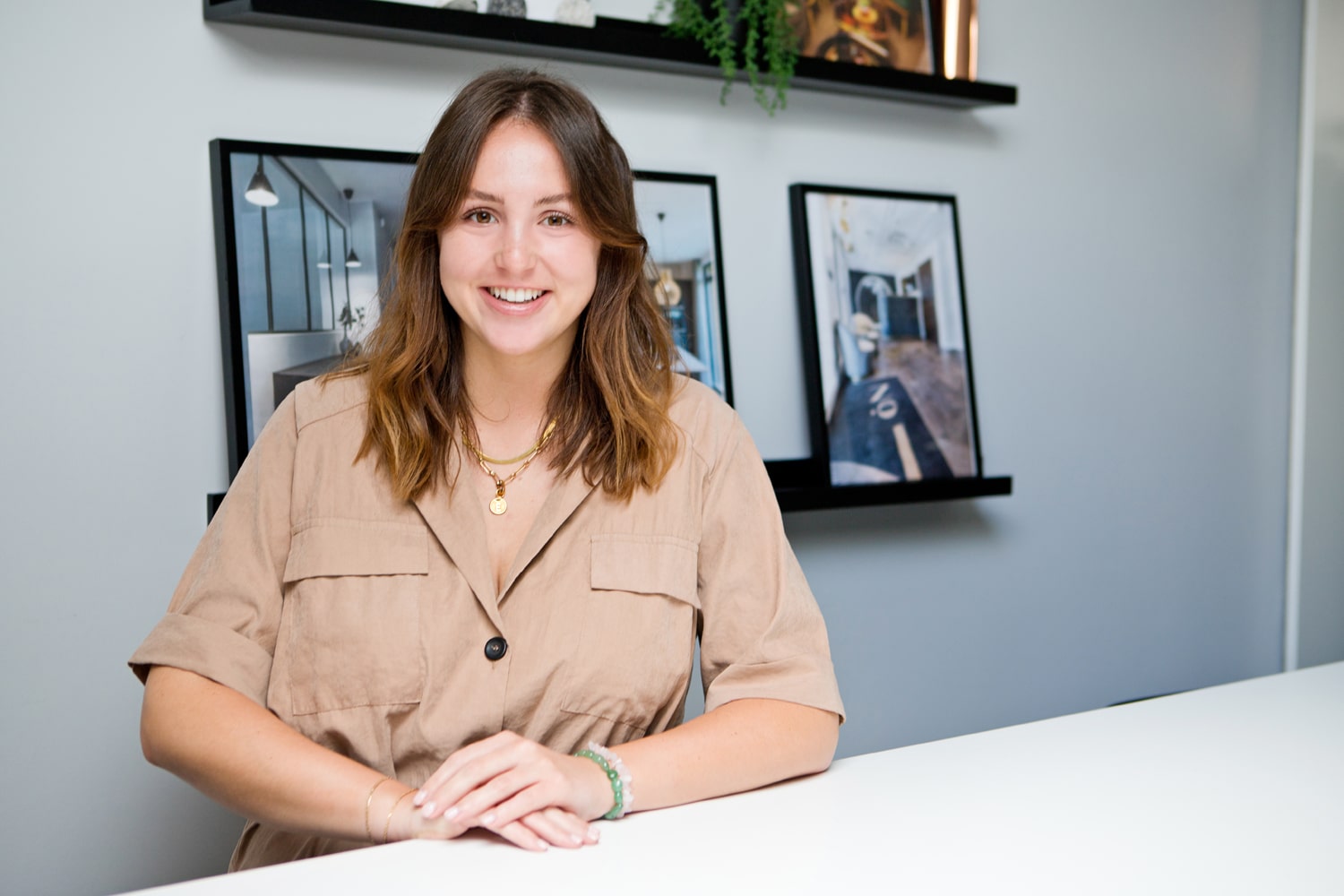 Emily Griffiths sitting in front of wall of interior artwork in JIGSAW's Poole Interior Architecture Office