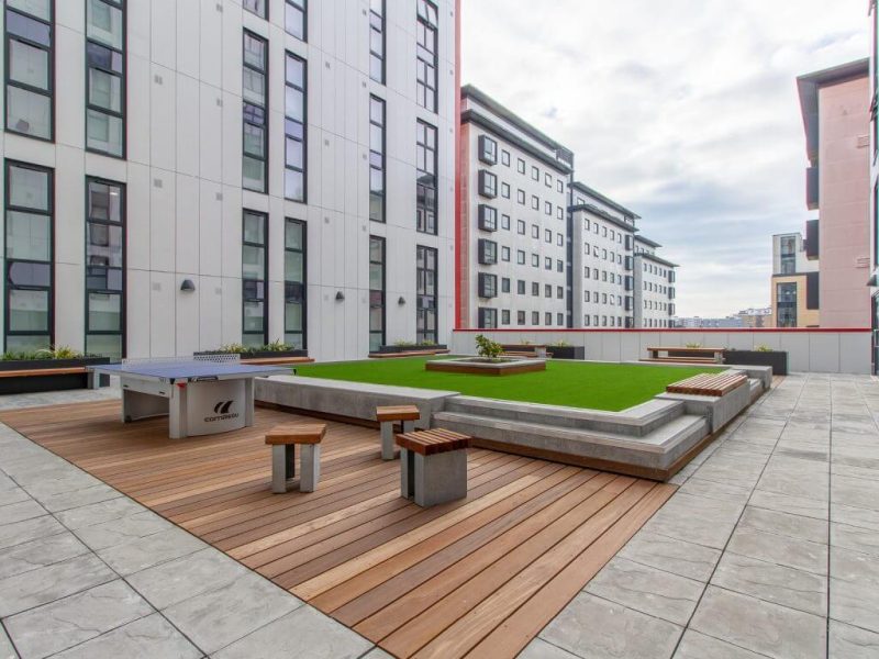 Roof terrace with decking, elevated greenery, scattered seating and ping pong table