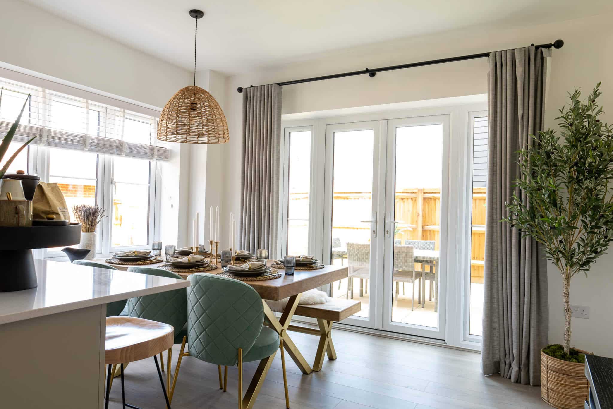 A picture of an open space dining area next to the kitchen, with large windows.