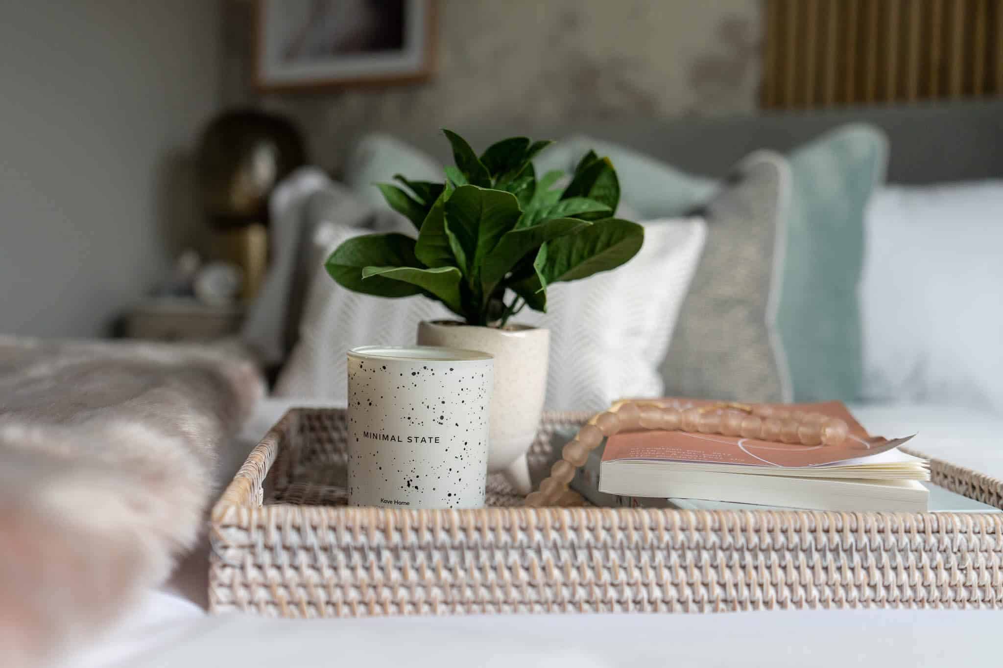 Picture of a plant, candle and book on a tray in the master bedroom